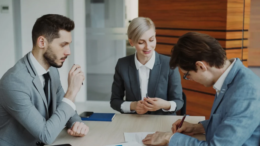 Lawyers and clients signing documents, protected by law firm cybersecurity
